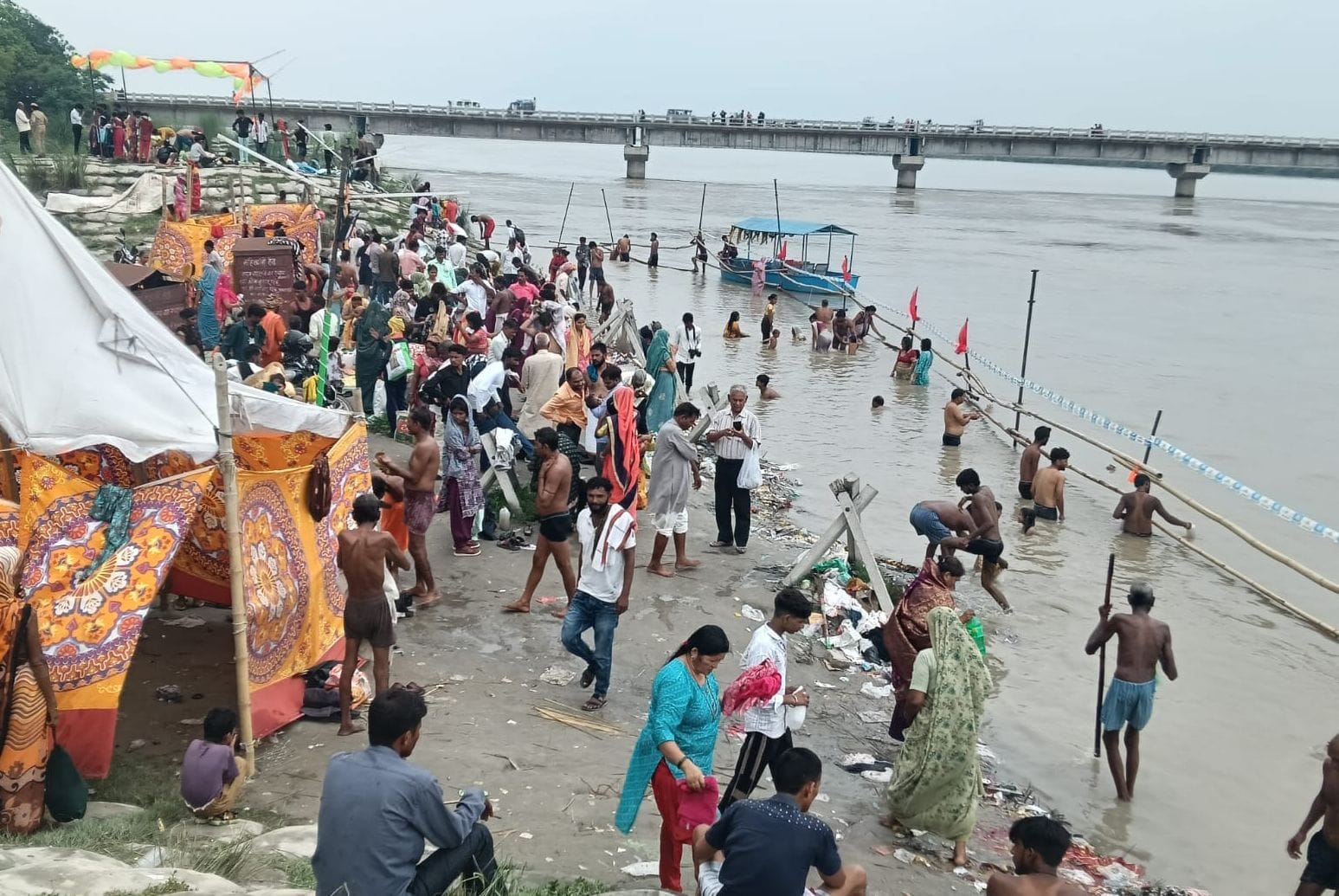 फोटो 10- सोरोंजी के लहरा गंगाघाट पर की गई बैरिकेडिंग के सहारे गंगास्नान करते । स्रोत संवाद