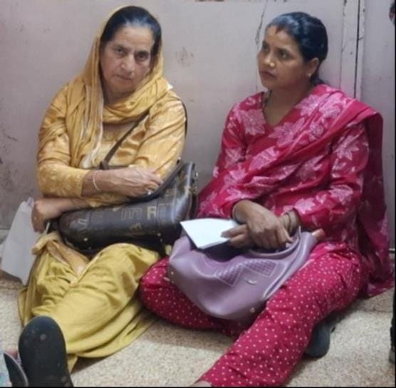 धर्मशाला अस्पताल में नेत्र रोग ओपीडी के बाहर जमीन पर बैठकर बारी की इंतजार करते हुए महिलाएं। अमर धर्मशाला अस्पताल में नेत्र रोग ओपीडी के बाहर जमीन पर बैठकर बारी की इंतजार करते हुए महिलाएं। अमर