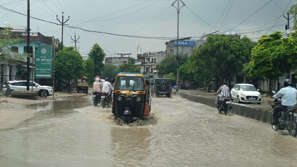 फोटो 32 करहल रोड पर दुकानों के सामने हुए जल भराव में से होकर गुजरती महिला। संवाद फोटो 32 करहल रोड पर दुकानों के सामने हुए जल भराव में से होकर गुजरती महिला। संवाद