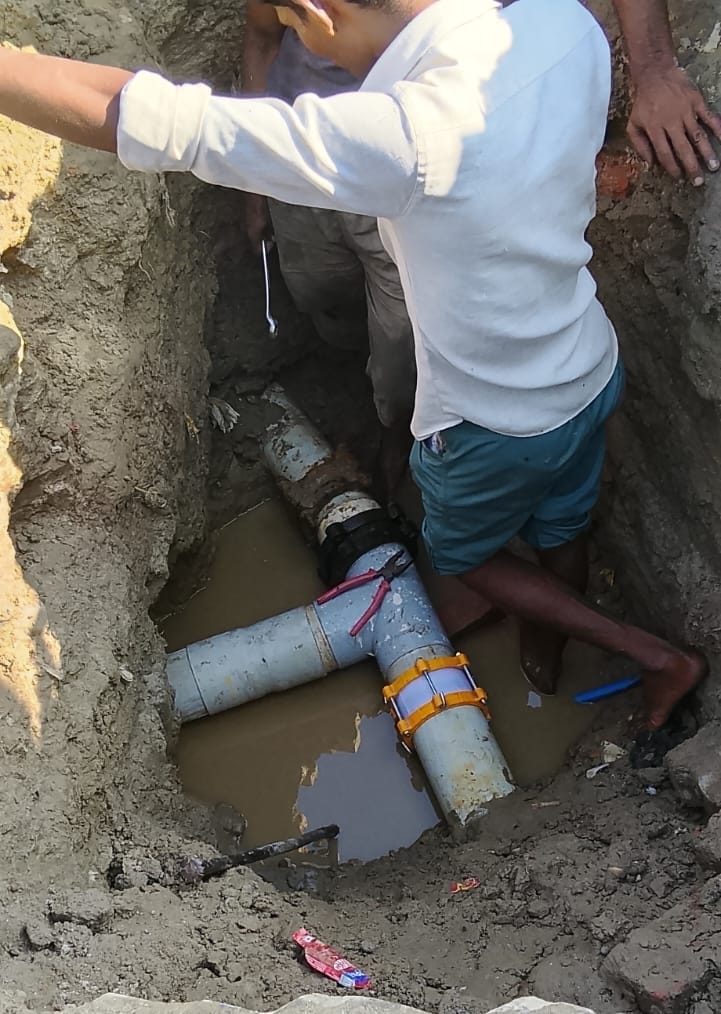 पाइपलाइन की मरम्मत करते कारीगर व टैंकर से पानी भरते लोग। संवाद