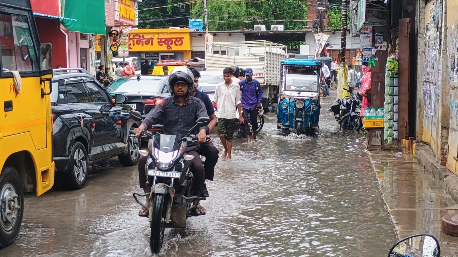 शहर के मिश्रबाजार में सड़क पर जलजमाव के बीच गुजरते बाइक सवार। संवाद