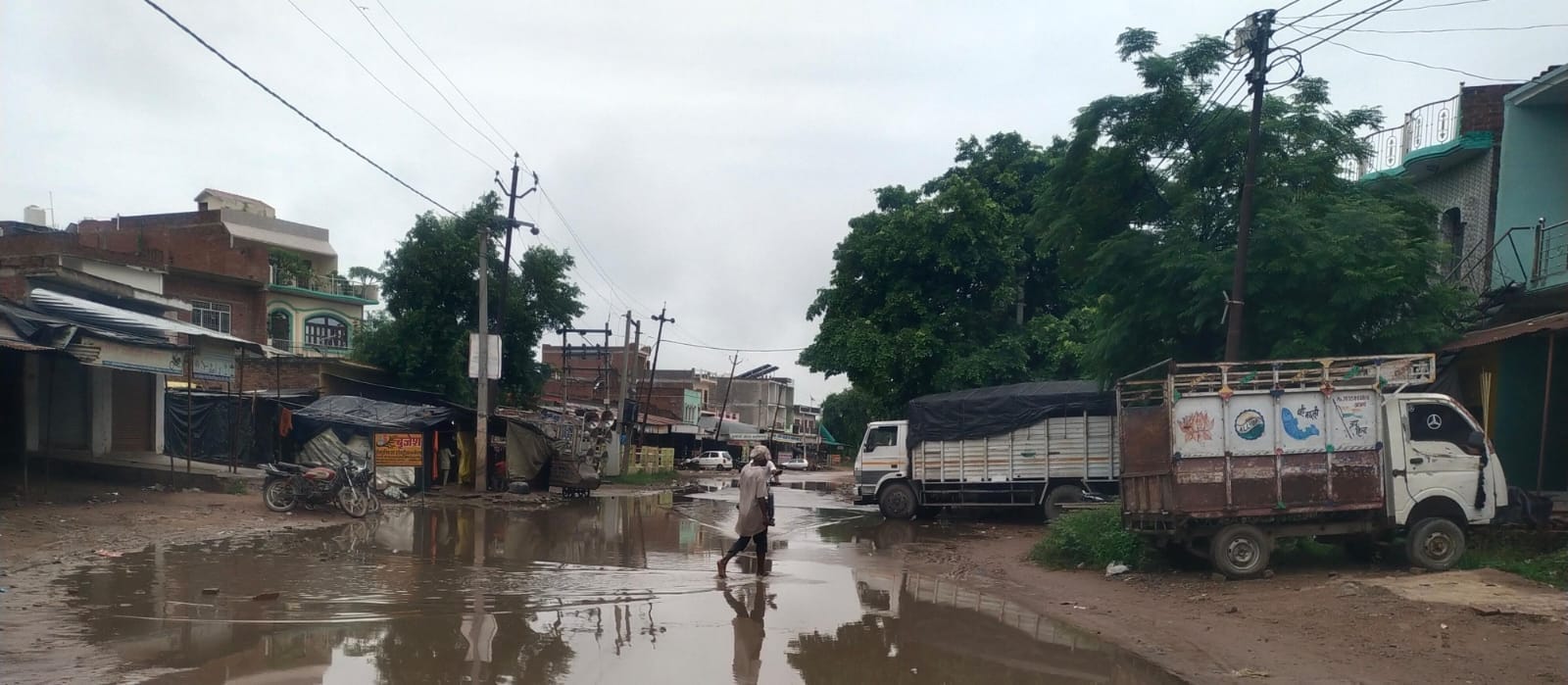 शहर के दिबियापुर रोड पर जलभराव के बीच निकलते वाहन। संवाद