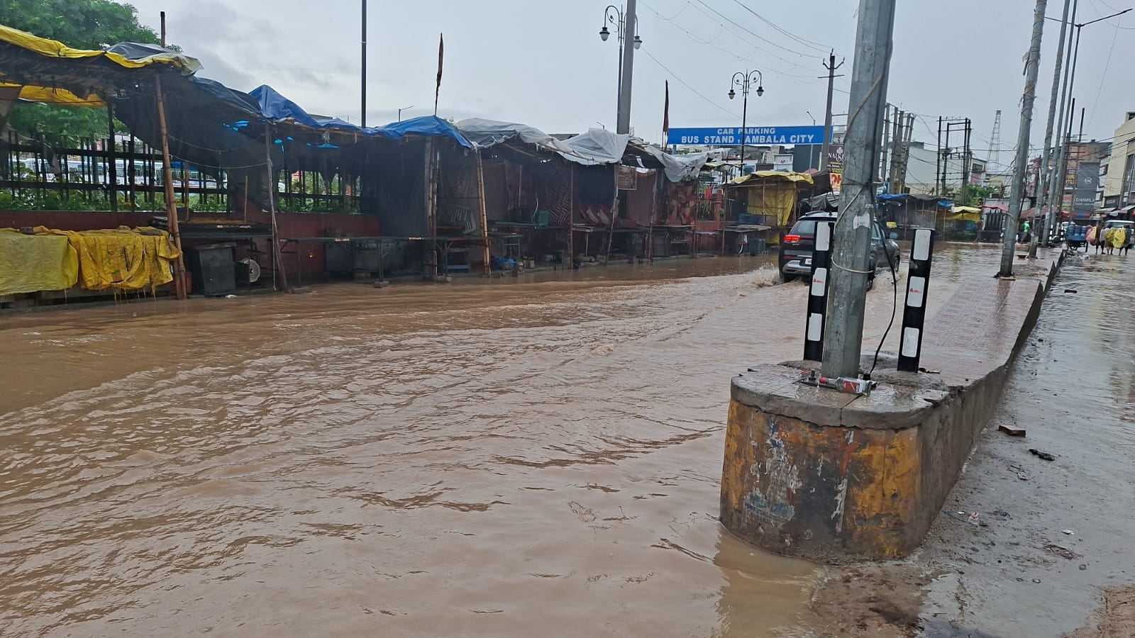 अंबाला में मंगलवार सुबह हो रही तेज बरसात के दौरान छाया अंधेरा और सड़क पर हुए जलभराव के बीच अपने अंबाला में मंगलवार सुबह हो रही तेज बरसात के दौरान छाया अंधेरा और सड़क पर हुए जलभराव के बीच अपने