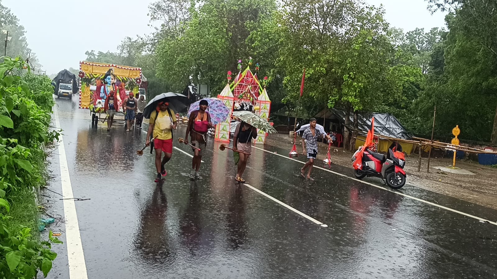 दौराला - दौराला में हाईवे पर बारिश के बीच अपने गंतव्य की ओर बढ़ते शिवभक्त। स्रोत : संवाद दौराला - दौराला में हाईवे पर बारिश के बीच अपने गंतव्य की ओर बढ़ते शिवभक्त। स्रोत : संवाद
