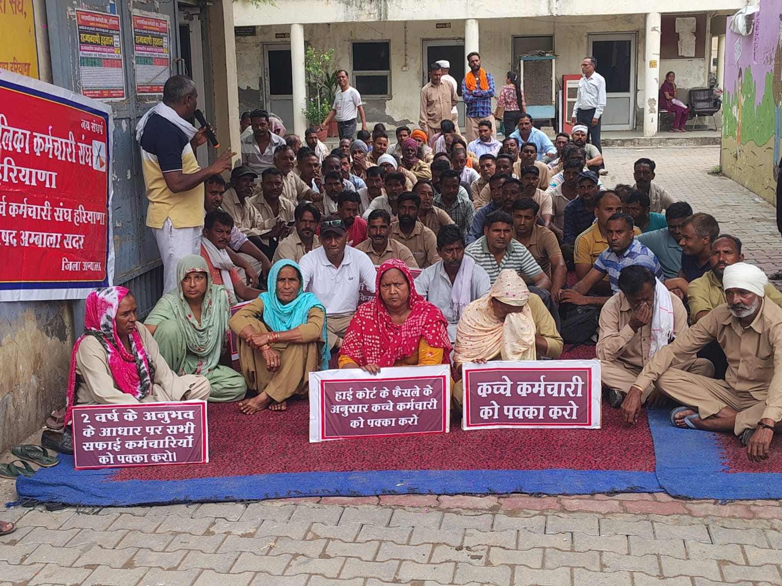अंबाला छावनी के नगर परिषद कार्यालय के गेट पर बैठ प्रदर्शन करते सफाई कर्मचारी। संवाद अंबाला छावनी के नगर परिषद कार्यालय के गेट पर बैठ प्रदर्शन करते सफाई कर्मचारी। संवाद