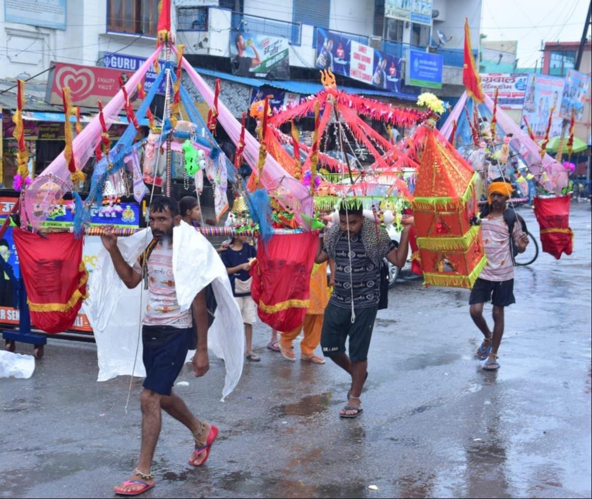 बारिश के बीच शहर के मुजफ्फरनगर रोड से कांवड़ लेकर जातीं महिला शिवभक्त। संवाद बारिश के बीच शहर के मुजफ्फरनगर रोड से कांवड़ लेकर जातीं महिला शिवभक्त। संवाद