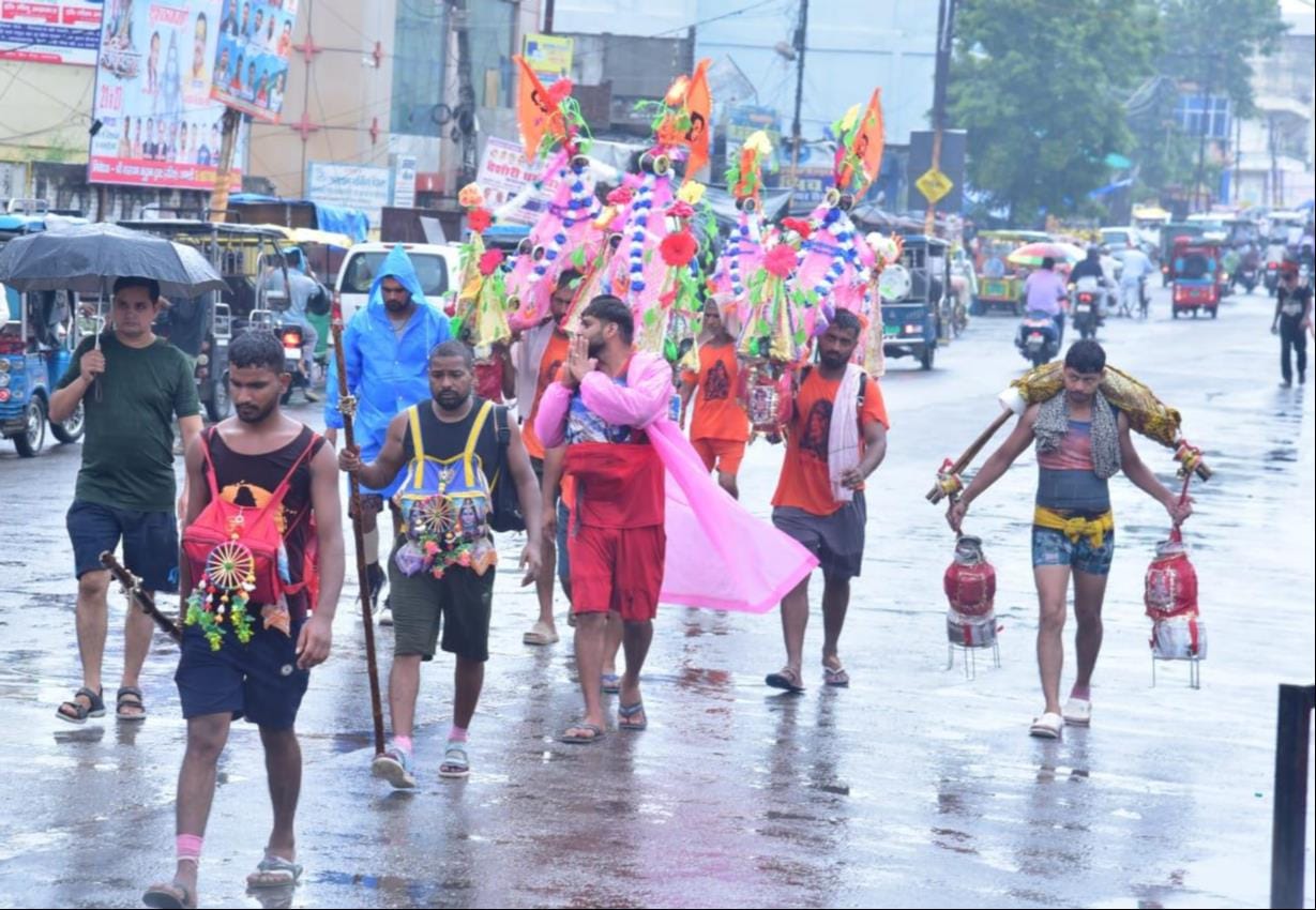 बारिश के बीच शहर के मुजफ्फरनगर रोड से कांवड़ लेकर जातीं महिला शिवभक्त। संवाद बारिश के बीच शहर के मुजफ्फरनगर रोड से कांवड़ लेकर जातीं महिला शिवभक्त। संवाद