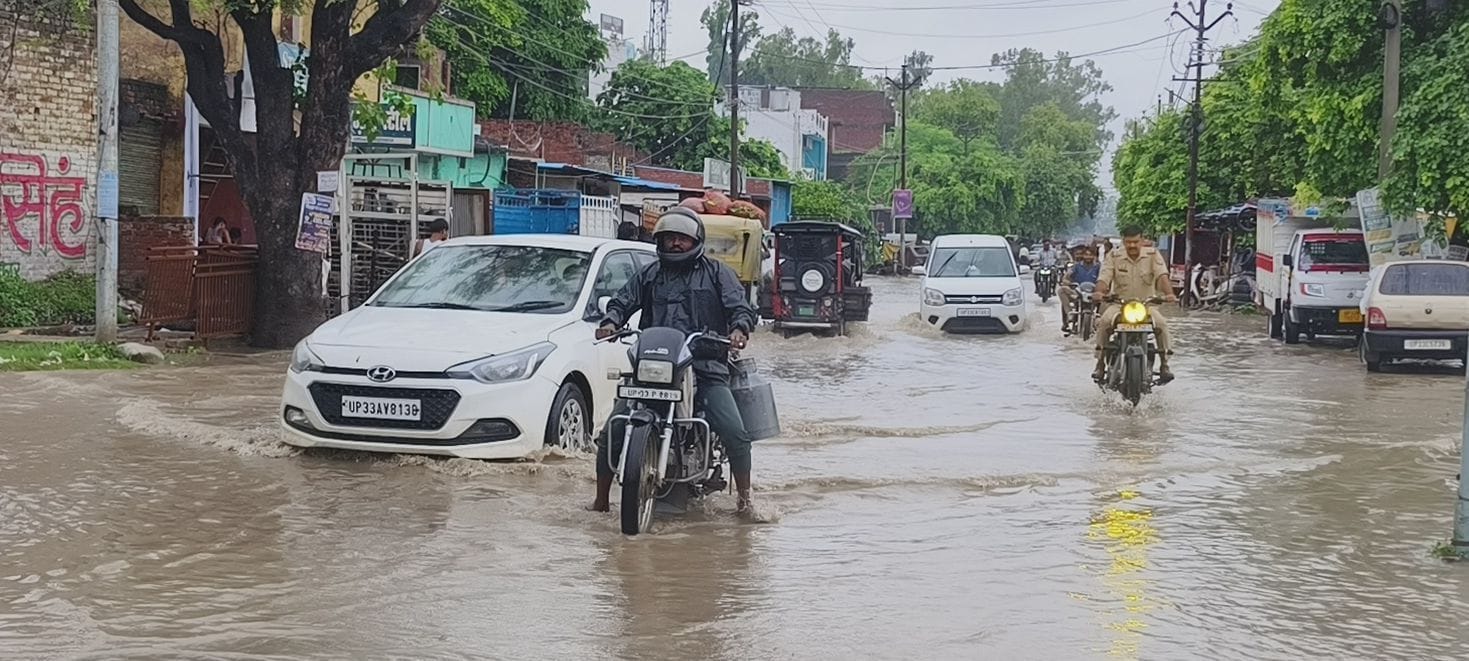 एकता विहार कॉलोनी स्थित रतापुर रोड पर जलभराव से होकर निकलते वाहन। 