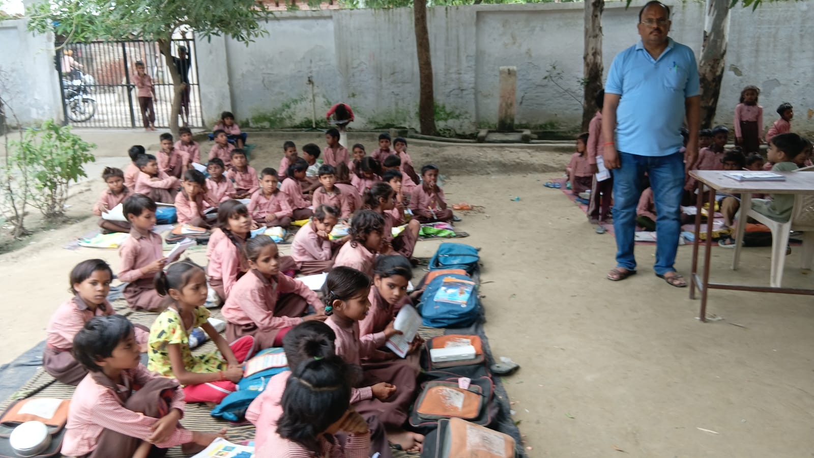 देवकली में स्कूल का भवन ध्वस्त होने के बाद पेड़ के नीचे बैठकर पढ़ते छात्र-छात्राएं। संवाद