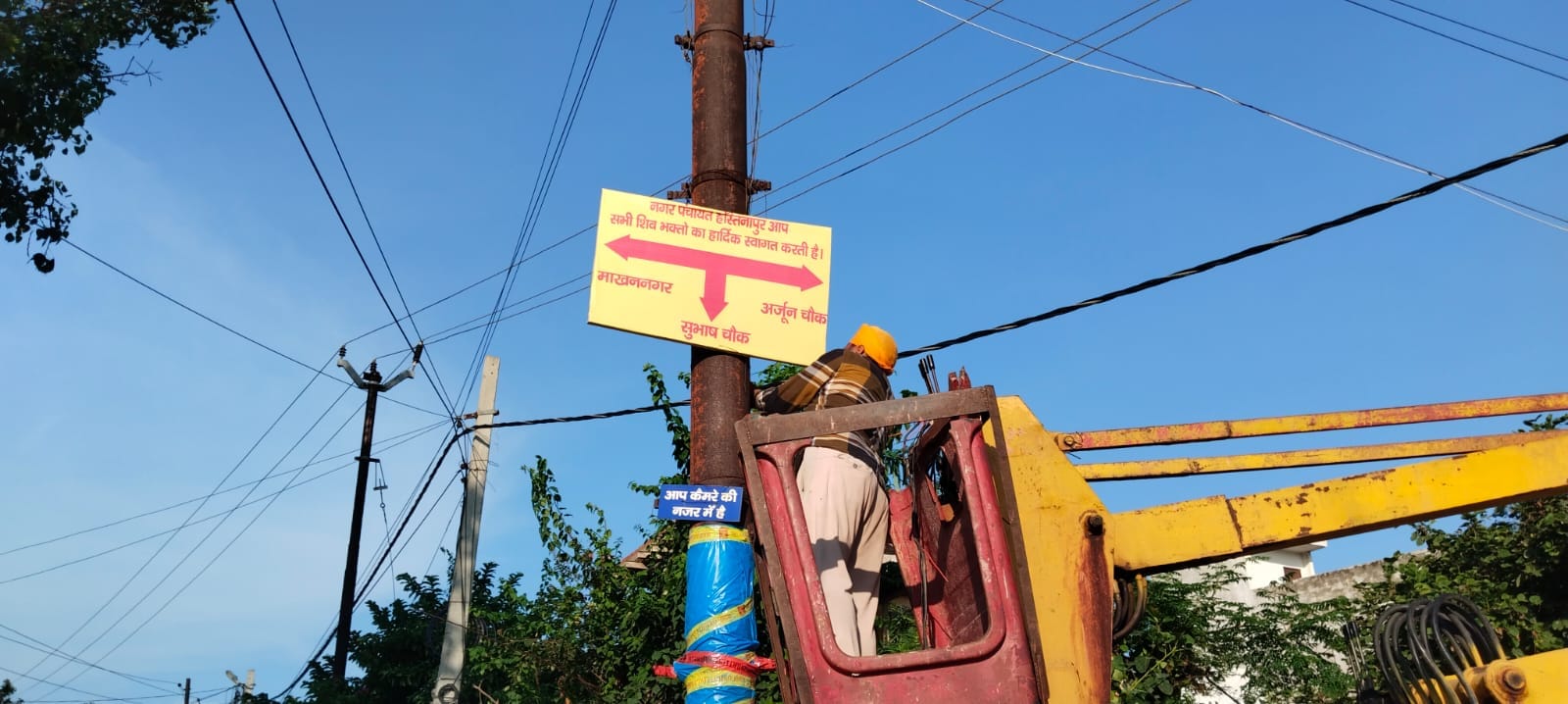 कस्बे में दिशा सूचक लगाते नगर पंचायत की टीम स्रोत संवाद