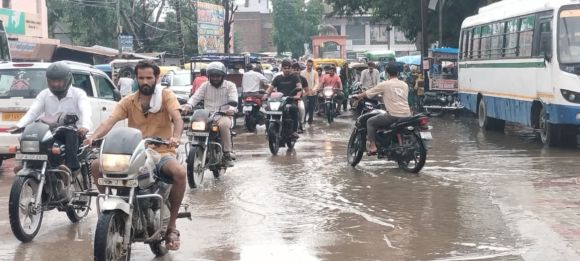 शनिवार दोपहर हुई बारिश के बाद सब्जी मंडी में हुए जलभराव से होकर गुजरते लोग। संवाद शनिवार दोपहर हुई बारिश के बाद सब्जी मंडी में हुए जलभराव से होकर गुजरते लोग। संवाद