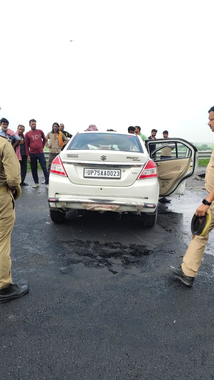 घटनास्थल पर खड़ी क्षतिग्रस्त कार, मौजूद पुलिस व लोग। संवाद