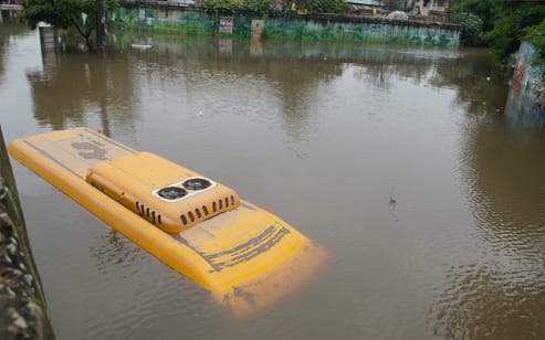 ओल्ड फरीदाबाद रेलवे अंडरपास में भरे बारिश के पानी में डूबी स्कूल बस को क्रैन से निकालते हुए। सं