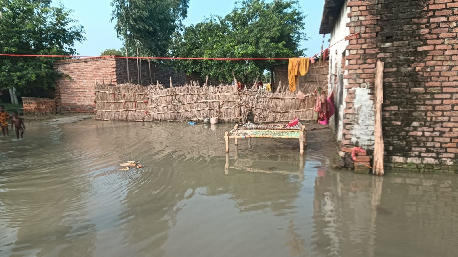 फोटो-21, समैचीपुर चितार गांव में भरे बाढ़ के पानी में खेलते बच्चे। संवाद