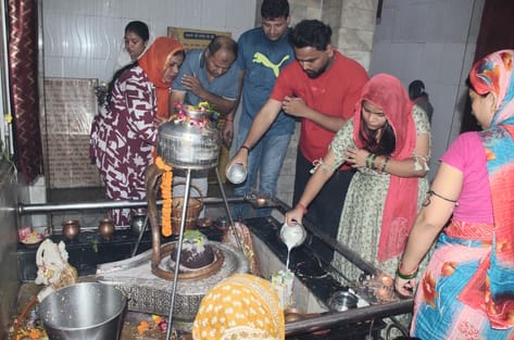 फरीदाबाद में सावन के दुसरे सोमवार को पूजा करने के लिए सैनिक कॉलोनी स्थित शिवालय में लाइन में 