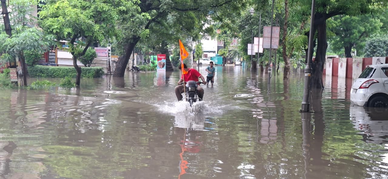 मटका चौक पर जलभराव के बीच से गुजरता कांवड़िया। संवाद