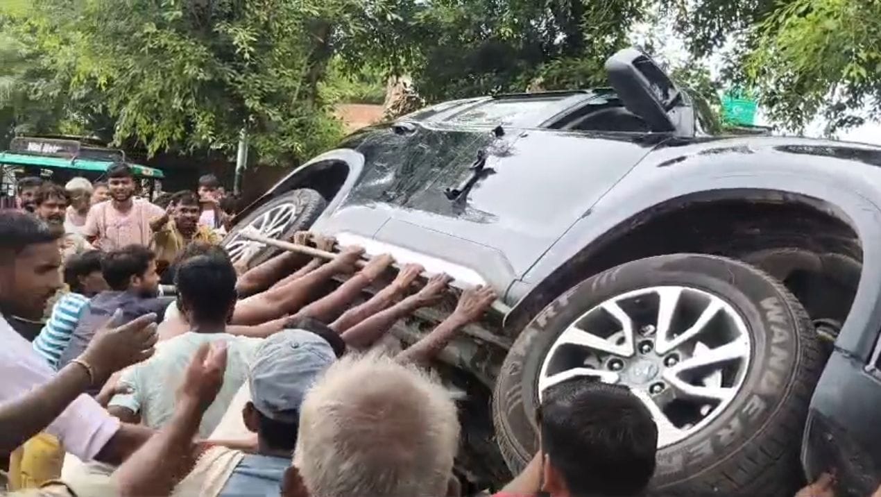 बिचपुरी पर कार के अंदर बैठा डॉक्टर और कार पलटते ग्रामीण। वीडियो ग्रेब