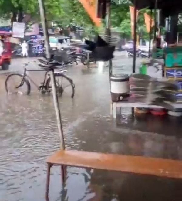 फोटो 04 एमएएचपी 06 परिचय-पुराने इंडियन बैंक के पास सड़क पर हुए जलभराव के बीच निकलते लोग। संवाद