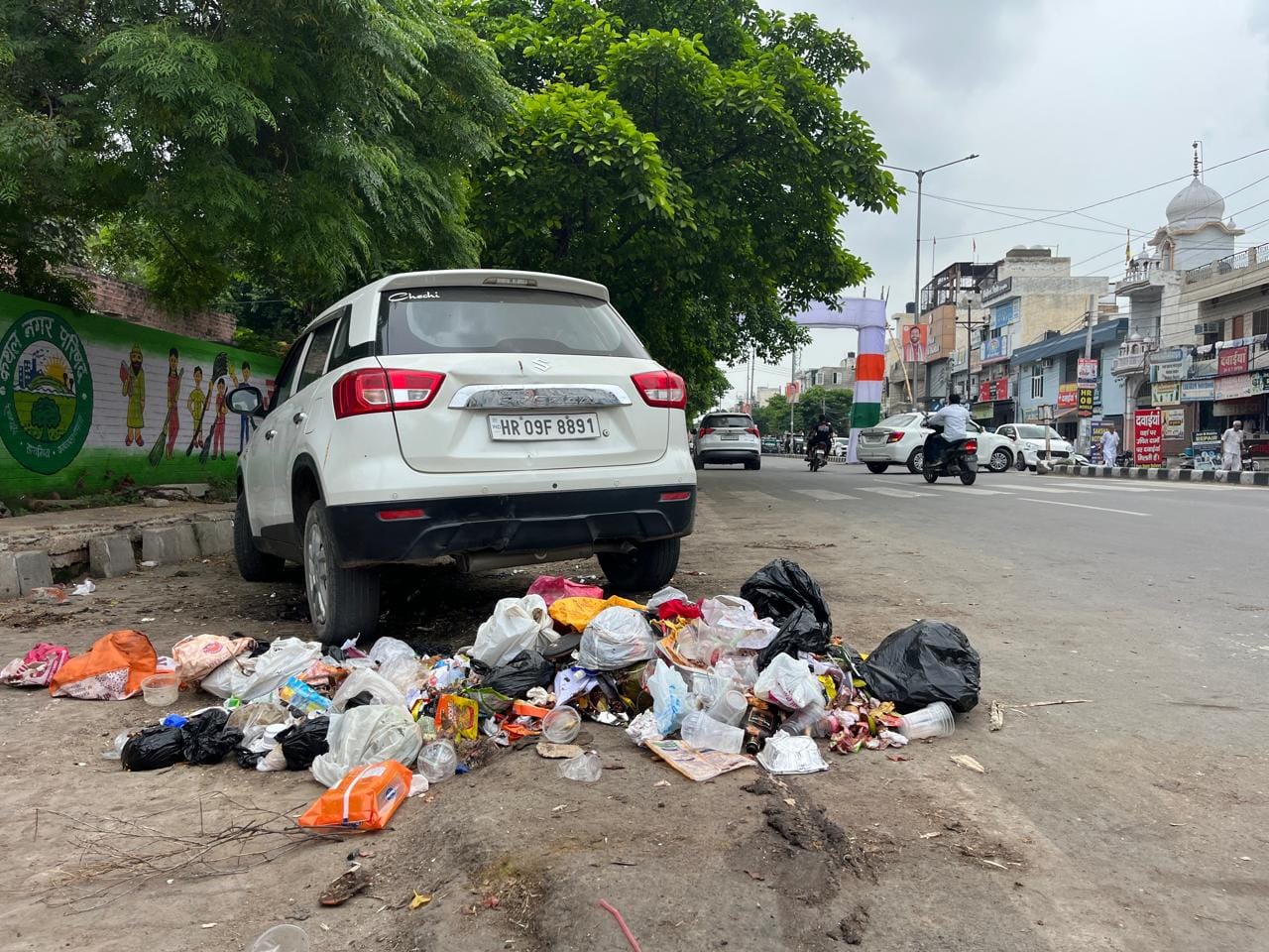 अंबाला रोड पर मुख्यातिथि एवं मंत्री कृष्ण बेदी के बैनर के नीचे पड़ी गंदगी। संवाद