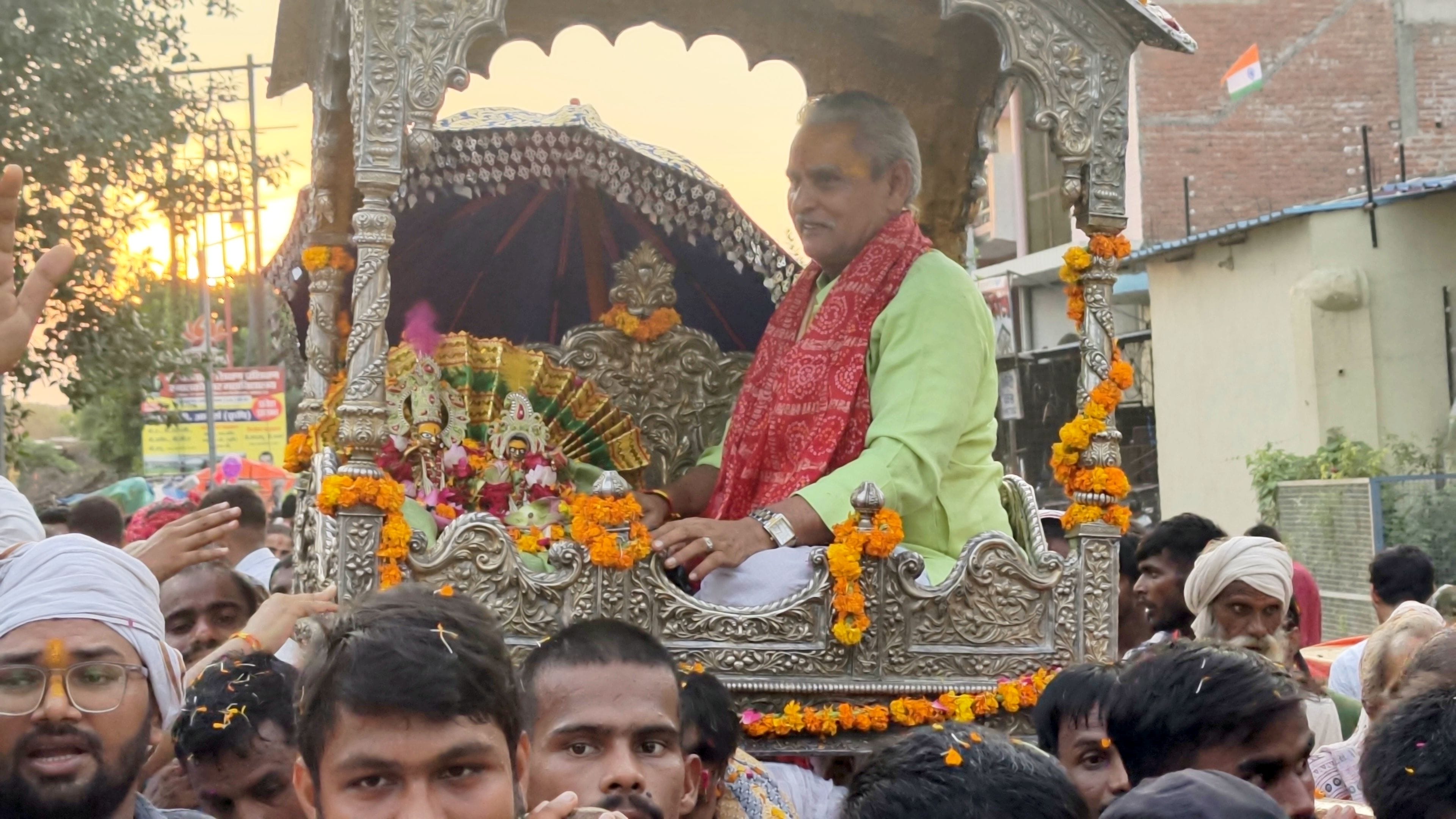 भगवान के स्वरूप को झूला झुलाते श्रद्धालुगण।