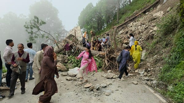 बंद सड़क को पैदल पार करते लोग