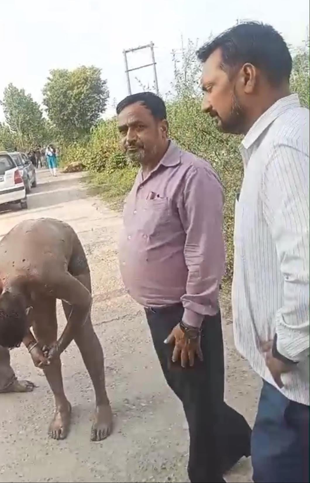 आत्महत्या का प्रयास करने वाले किसान को उठाते उसके परिजन। वीडियोग्रैब