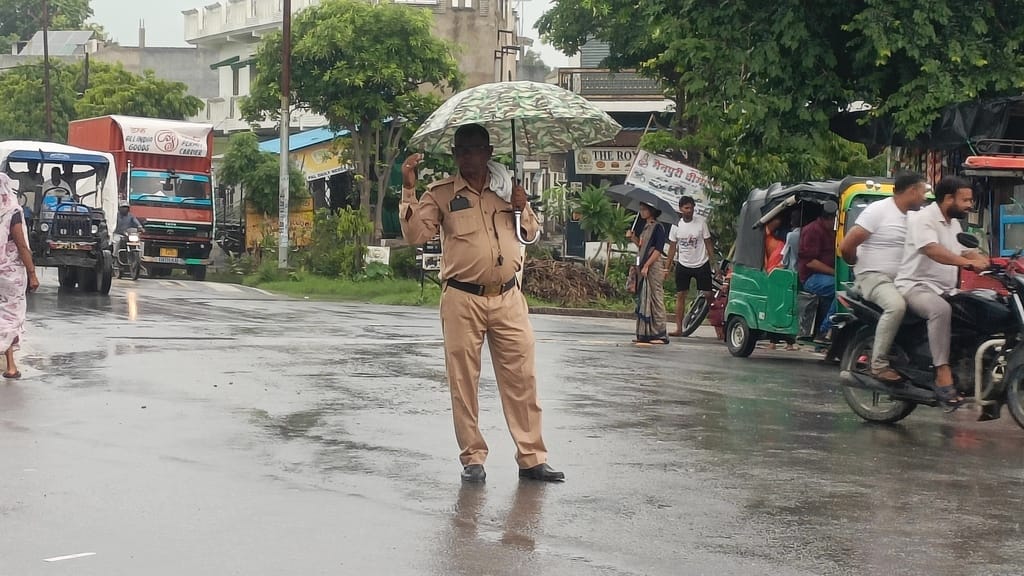 फोटो 17 बारिश से बचने के लिए सिर के ऊपर कुर्सी रखकर जाता युवक।  संवाद