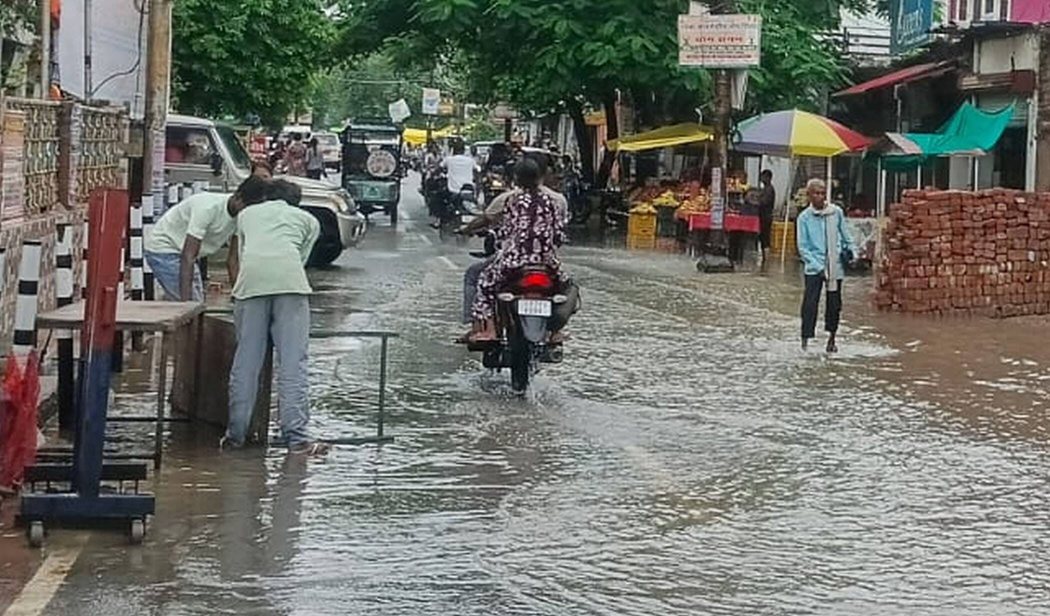 फोटो-23-बारिश की फुहारों के बीच सड़कों पर निकलते लोग। संवाद