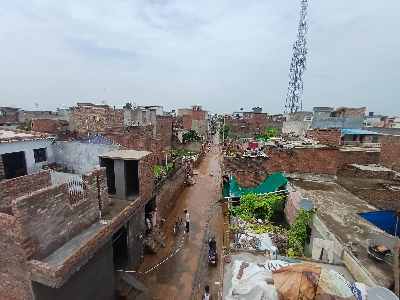 घर के बाहर जमा कीचड़ को साफ करते यश और आरव व अन्य। संवाद