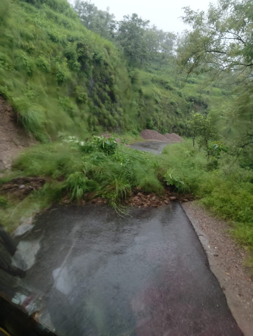 कश्मीर गांव में मुख्य सड़क के साथ भूस्खलन के कारण मकानों में घुसे मलबे से हुए नुकसान का आकलन कर