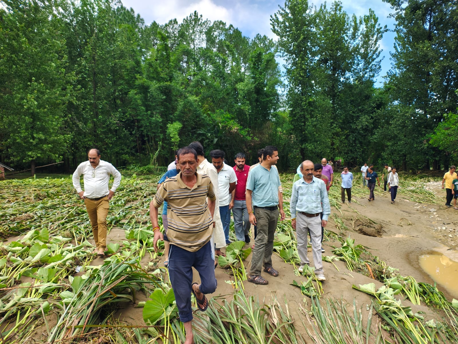 कश्मीर गांव में मुख्य सड़क के साथ भूस्खलन के कारण मकानों में घुसे मलबे से हुए नुकसान का आकलन कर
