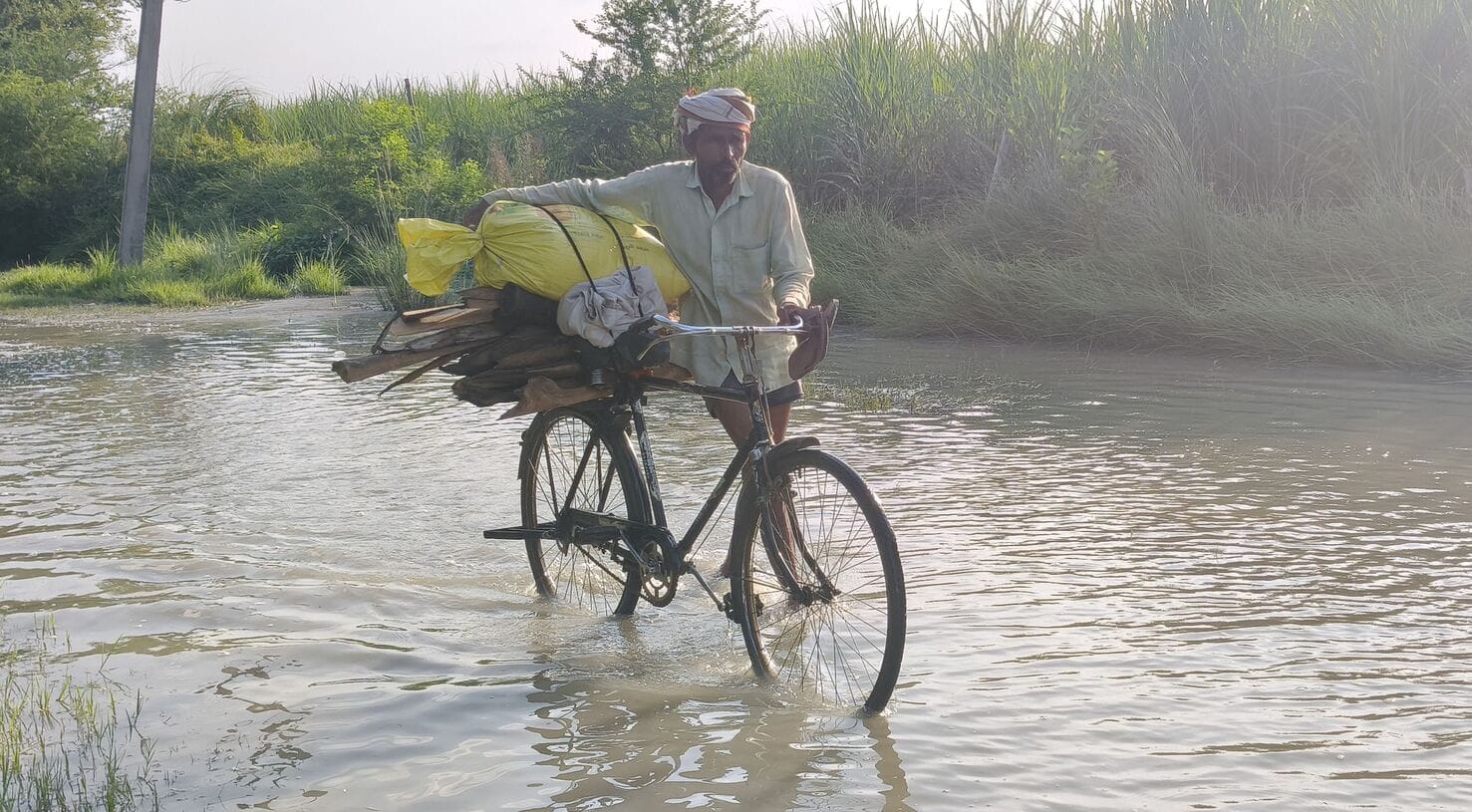 सरयू का जलस्तर बढ़ने के बाद कोटसराय के माझा कला में साइकिल के साथ गंतव्य की ओर जाते स्थानीय ग्र सरयू का जलस्तर बढ़ने के बाद कोटसराय के माझा कला में साइकिल के साथ गंतव्य की ओर जाते स्थानीय ग्र