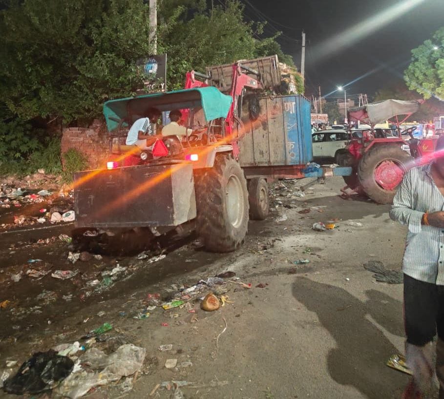 43-शहर के हुडा कांप्लेक्स में लगे गंदगी के ढेर के पास से मुंह पर हाथ रखकर गुजरता दुपहिया वाहन 