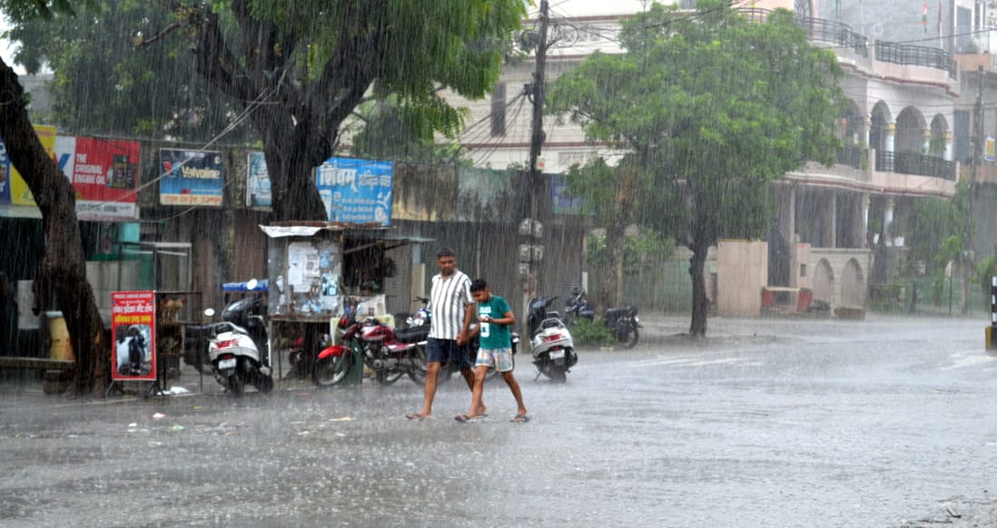 रविवार दोपहर को प्रेमनगर में बारिश के बीच दौड़ता युवक। संवाद