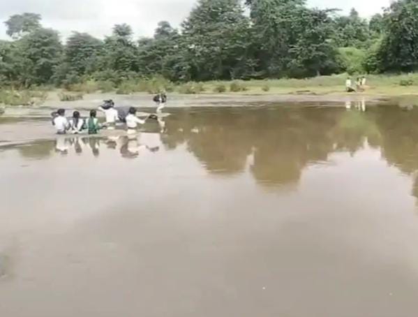 उफनती नदी पार कर स्कूल पहुंच रहे बच्चे