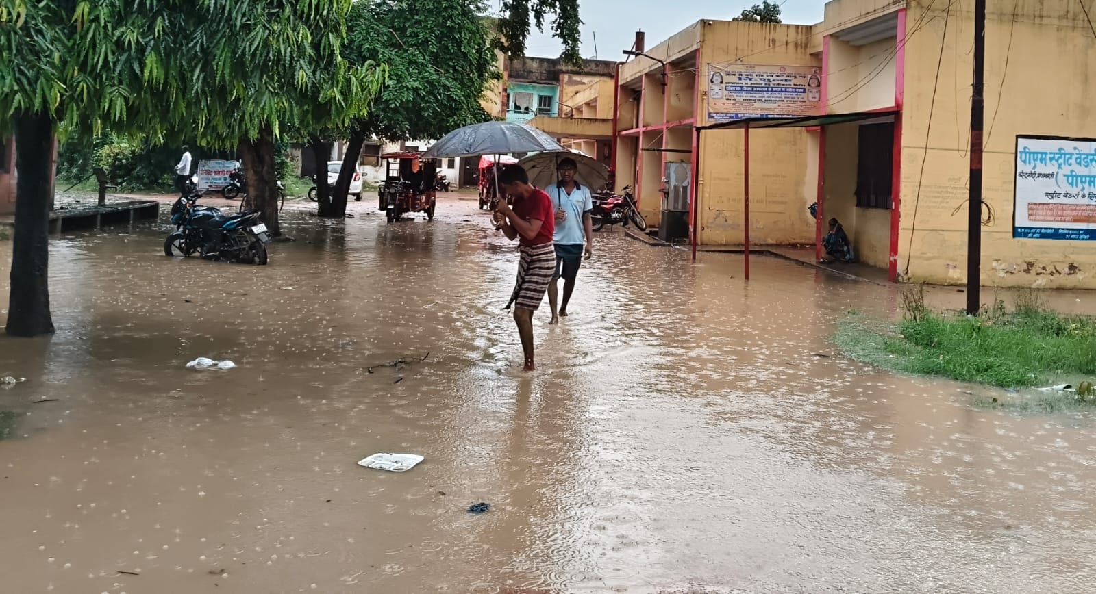 फोटो-26-इंदिरा नगर में जलभराव के बीच बेटी को स्कूल से लेकर लौटती महिला।