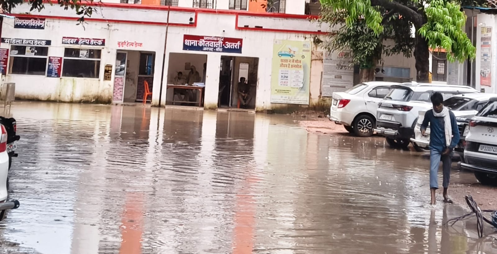 फोटो-26-इंदिरा नगर में जलभराव के बीच बेटी को स्कूल से लेकर लौटती महिला।