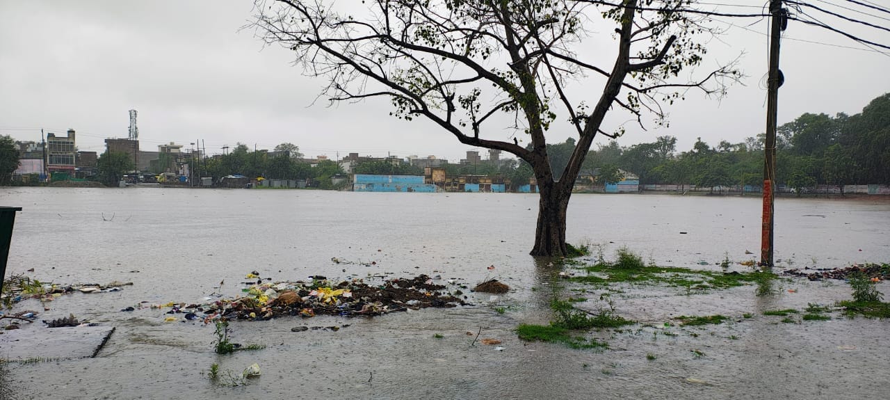 फोटो-26-इंदिरा नगर में जलभराव के बीच बेटी को स्कूल से लेकर लौटती महिला।