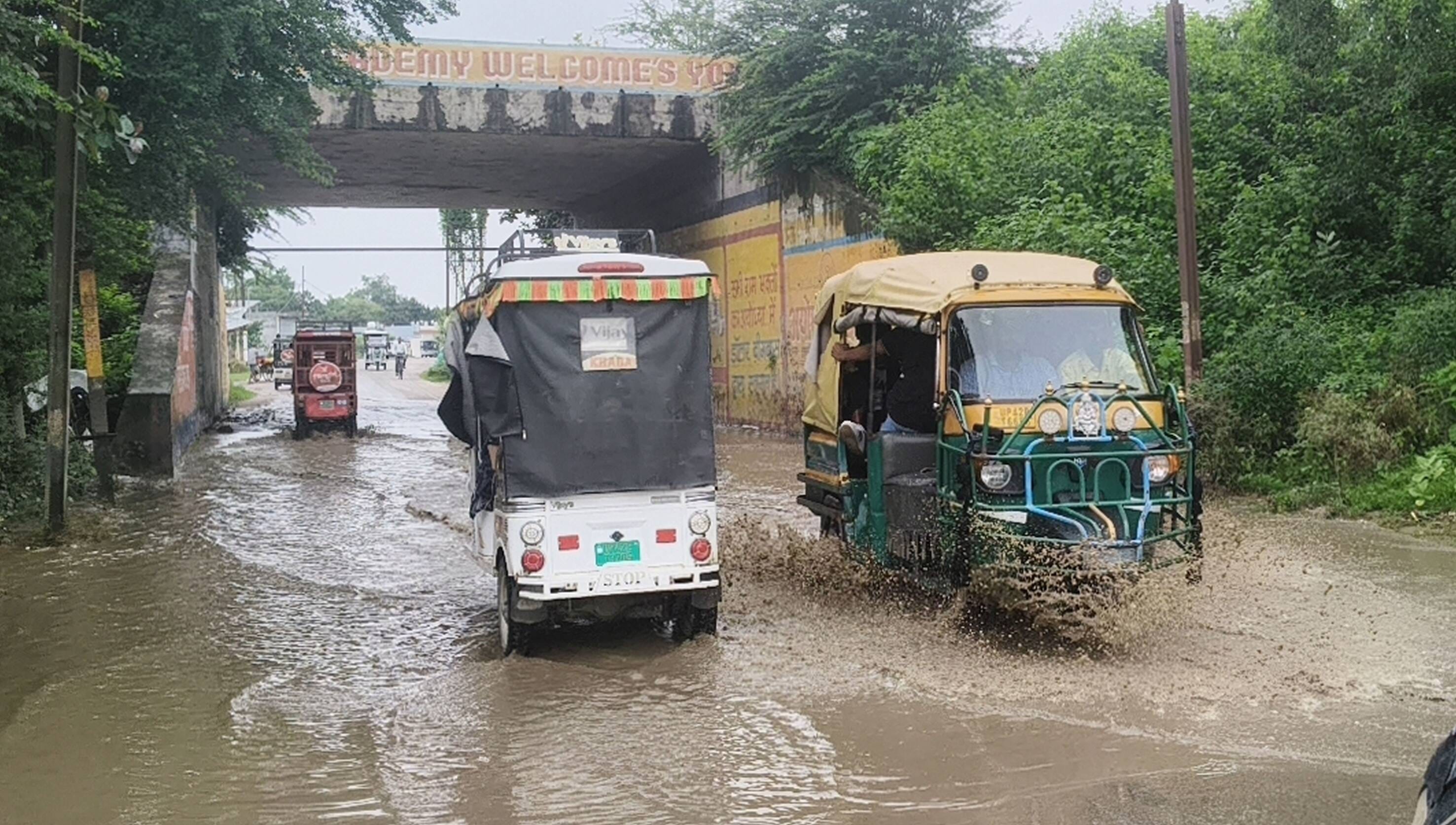 जनौरा में बारिश के बाद हुए जलभराव के बीच से होकर गुजरते वाहन।