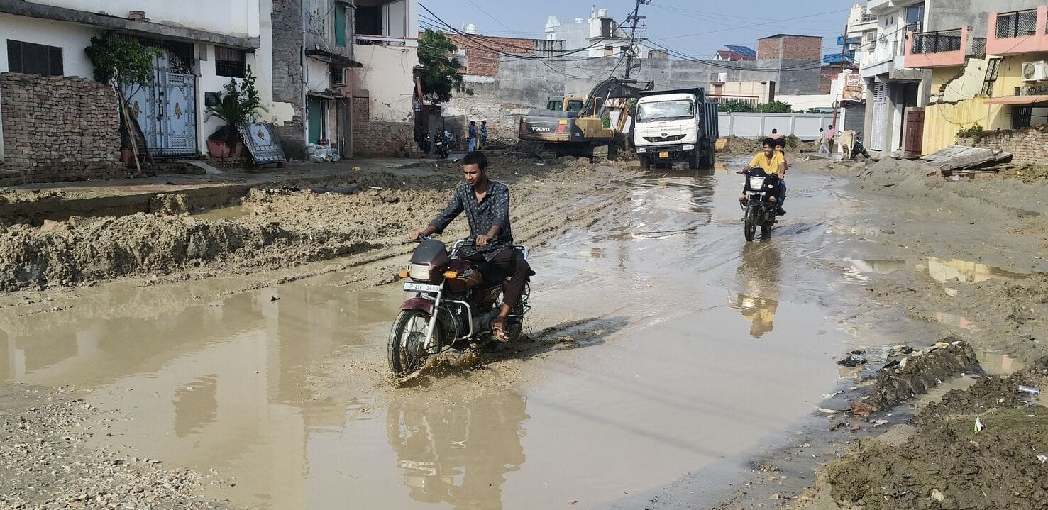 जनौरा में बारिश के बाद हुए जलभराव के बीच से होकर गुजरते वाहन।