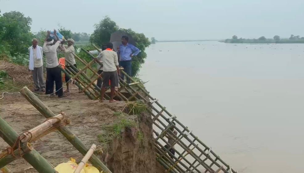 जलालाबाद-शमसाबाद स्टेट हाईवे पर भरे पानी से गुजरते लोग। संवाद