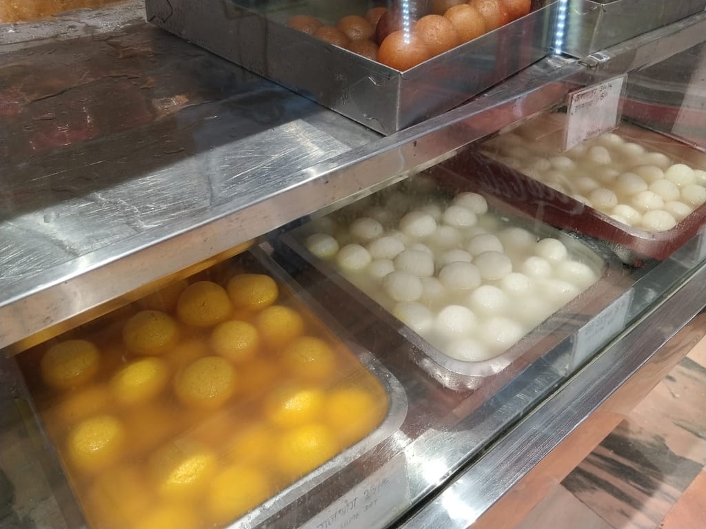 राखी खरीदती महिलाएं,दुकान में सजी मिठाइयां