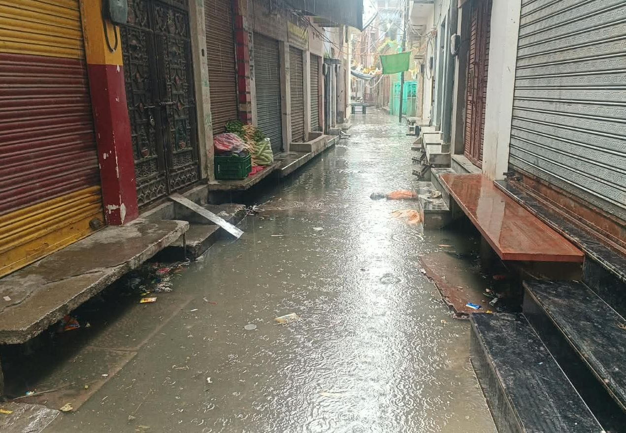 फोटो01बिलराम गेट लक्ष्मी सिनेमा के पास बारिश के दौरान जलभराव के बीच से होकर निकलते लोग। संवाद