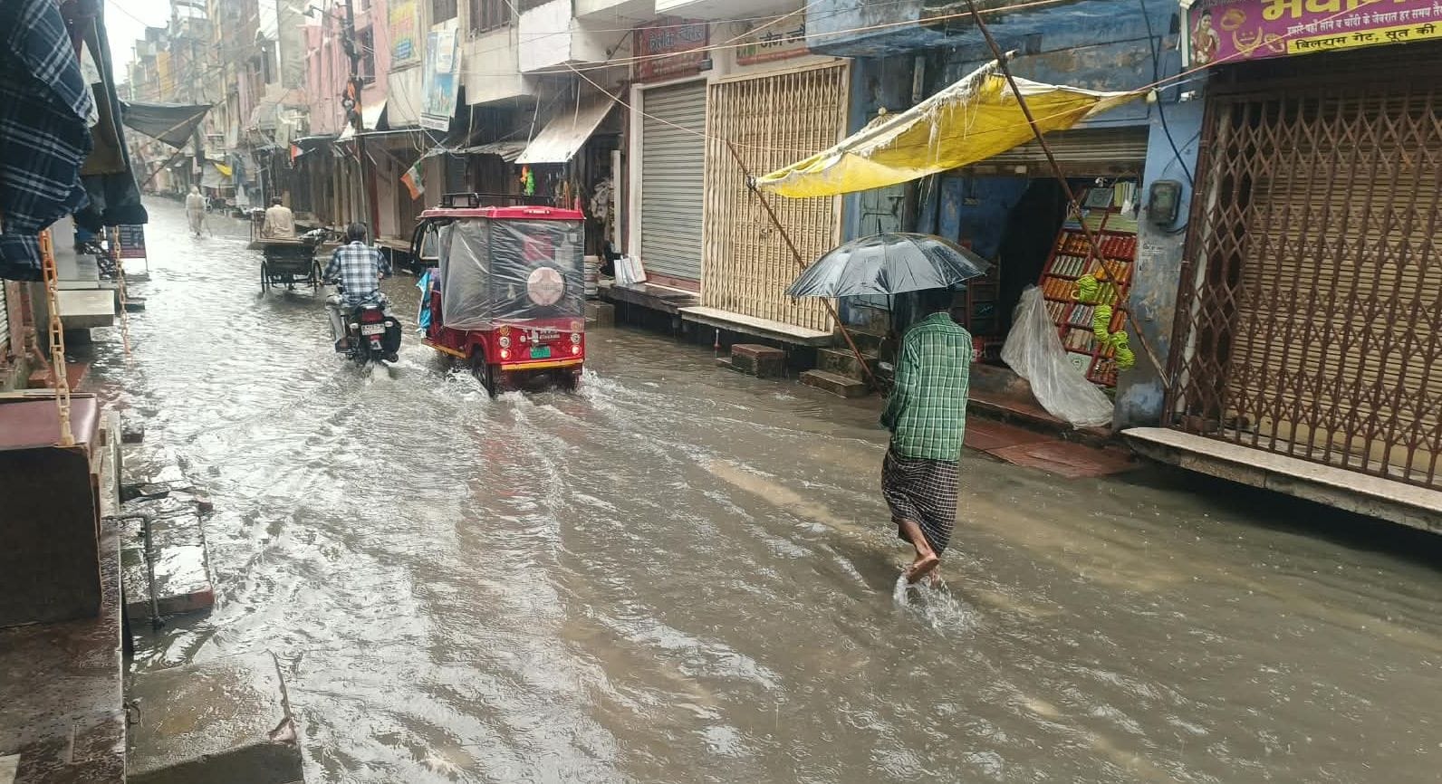 फोटो01बिलराम गेट लक्ष्मी सिनेमा के पास बारिश के दौरान जलभराव के बीच से होकर निकलते लोग। संवाद
