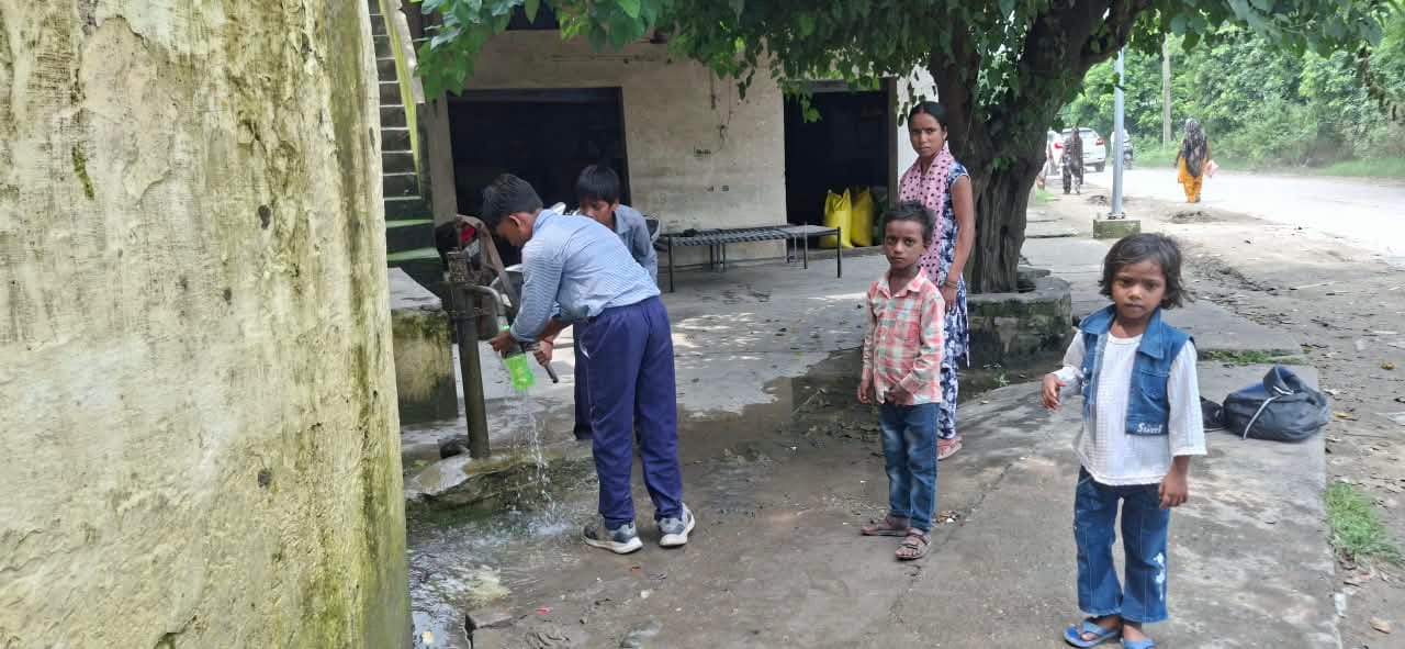 स्कूल में गंदा पानी आने पर बाहर सड़क पर लगे हैंडपंप से पानी भरते बच्चे। संवाद स्कूल में गंदा पानी आने पर बाहर सड़क पर लगे हैंडपंप से पानी भरते बच्चे। संवाद