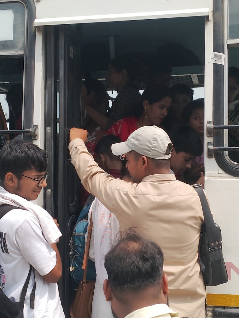 बस स्टैंड पर बस के इंतजार में खड़े यात्री। संवाद बस स्टैंड पर बस के इंतजार में खड़े यात्री। संवाद