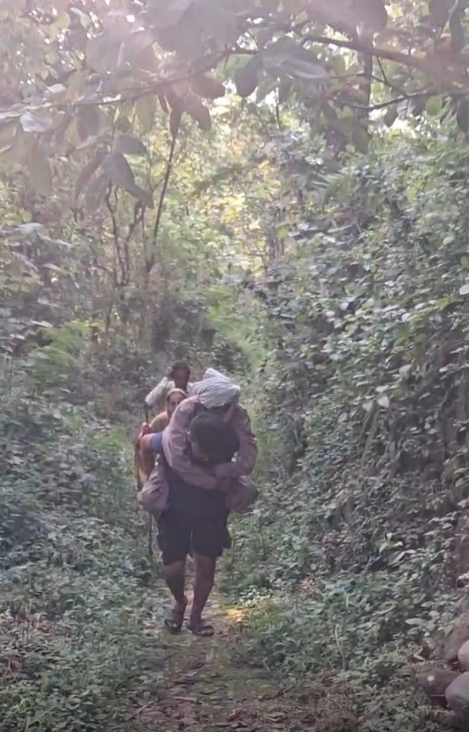 ग्राम पंचायत साहन्वीं के गांव बढ़ार के लोग बुजुर्ग को पकड़कर मुख्य सडक तक ले जाते हुए। संवाद