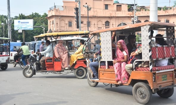 कैसरबाग चौराहे पर ई रिक्शा में सवारी भरते चालक।