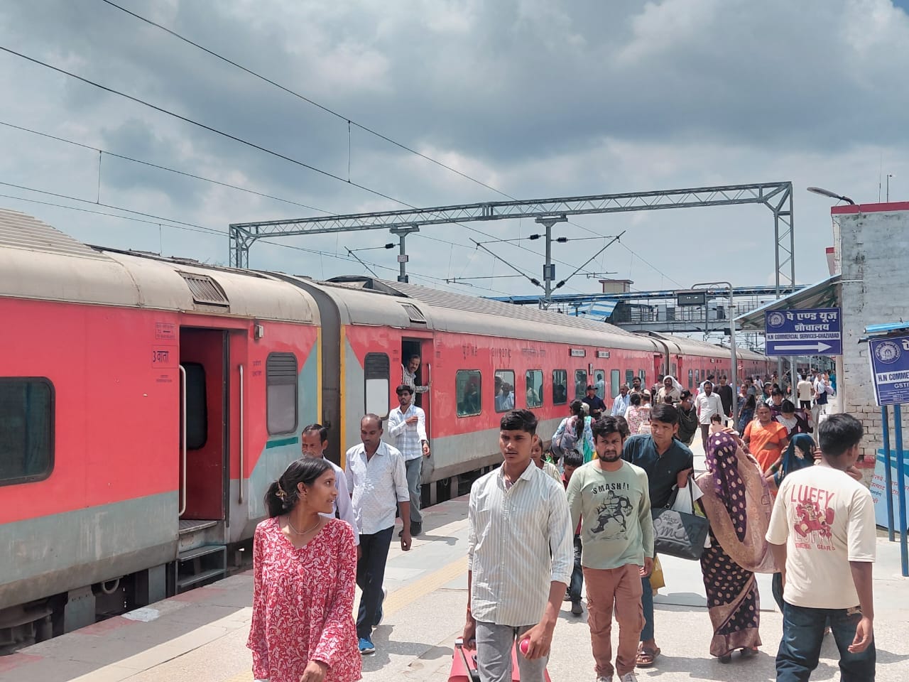 बस के आने पर सीट पाने के लिए खिड़की से बस में बैग रखता युवक। संवाद