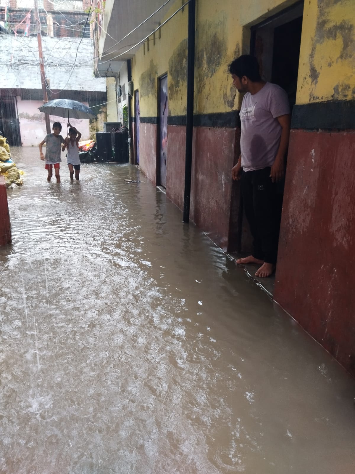 नैनी। जमुना नगर मोहल्ले में गली में भरे बारिश के पानी में खेलते बच्चे। स्रोत मोहल्ला वासी नैनी। जमुना नगर मोहल्ले में गली में भरे बारिश के पानी में खेलते बच्चे। स्रोत मोहल्ला वासी